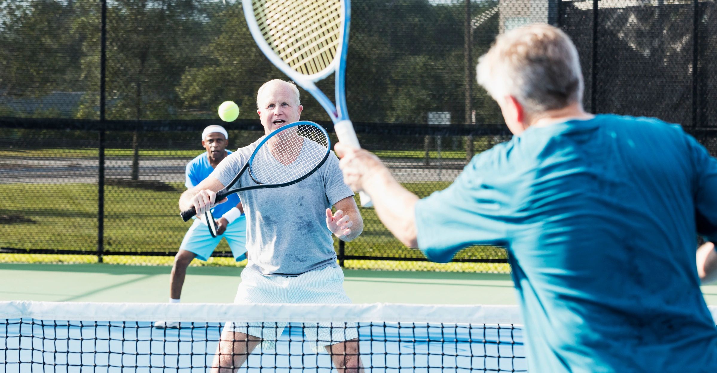 Adult doubles tennis match in progress